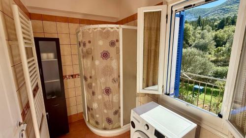 a bathroom with a shower and a large window at KAZARMA Luxury House in Pilikáta