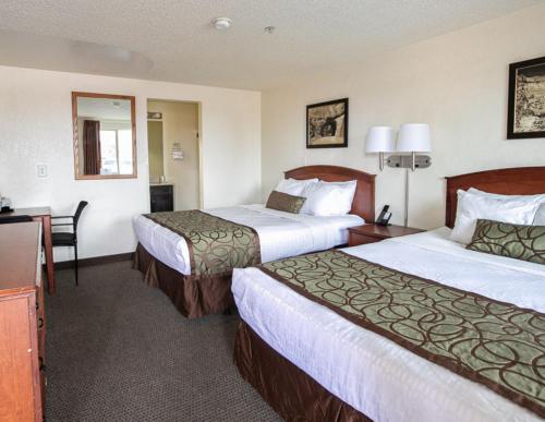 a hotel room with two beds and a desk at Bryce View Lodge Part of the Ruby's Inn Resort in Bryce Canyon