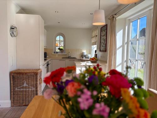 a kitchen with a table with a vase of flowers at Salig Hüs in Kampen