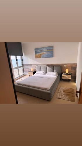 a bedroom with a large bed and a large window at Teddy Apartment in Durrës