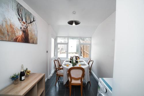 a dining room with a table with chairs and a painting at Home close to city center home in Milton Keynes