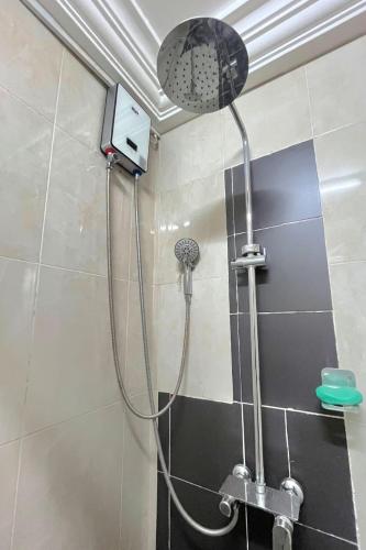 a shower with a shower head in a bathroom at Aburi Emerald Garden Retreat in Aburi