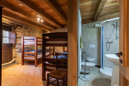 a room with bunk beds and a bathroom with a sink at Rifugio Ca' da Cardella in Mendatica