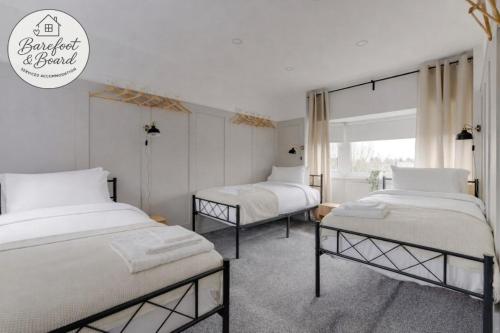 a bedroom with two beds and a window at Contractor friendly 3BDR Home | Parking for Vans in Salford