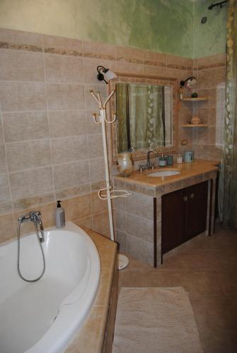 a bathroom with a bath tub and a sink at A&M House in Vignanello
