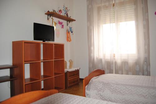 a bedroom with a bed and a dresser with a television at A&M House in Vignanello