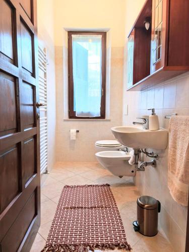 a bathroom with a sink and a toilet and a door at I sogni di Elias in Tuoro sul Trasimeno