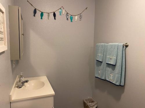 a bathroom with a sink and a toilet and towels at Rudolph's Reindeer Den in Ketchikan