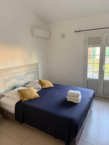 a bedroom with a blue bed with two towels on it at La jolie Villa in Le Lamentin