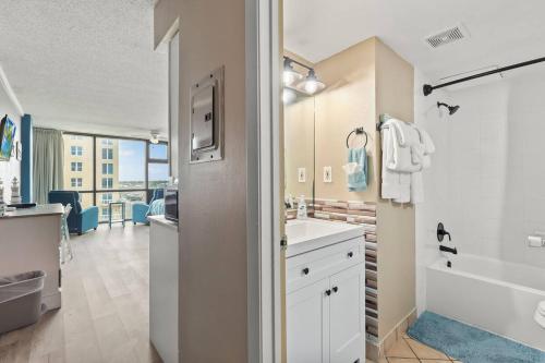 a bathroom with a sink and a tub at Ocean View Suites at Oceanside Inn in Daytona Beach