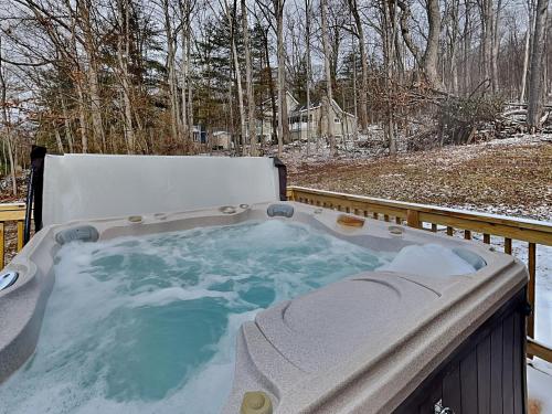 a jacuzzi tub on a deck in the snow at Fawn View Cabin in McHenry