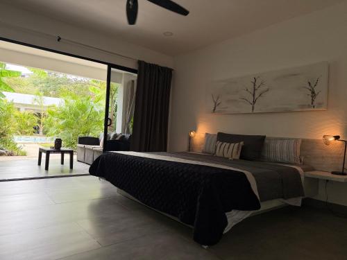 a bedroom with a large bed and a large window at Hotel Good Life in Coco