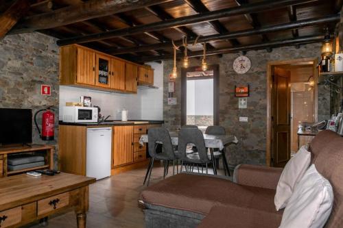 a kitchen and living room with a couch and a table at Di&Ana III - Alojamento Redondo in Redondo