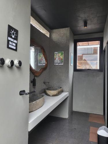 a bathroom with two sinks sitting on a counter at Hebe Hotel, Hostel & Hospitality Network in Sawah