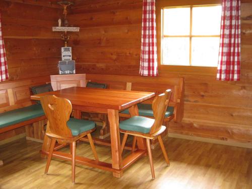 a dining room with a wooden table and chairs at Almhütte Adlerhorst in Heiligenblut