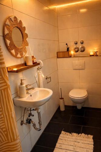 a bathroom with a sink and a toilet at CitySuite Borken Hessen in Borken