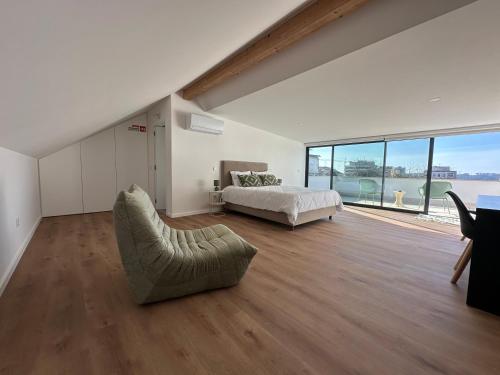 a bedroom with a bed and a large window at Loft Azeméis in Oliveira de Azemeis