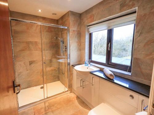 a bathroom with a shower and a sink at Ghyll Bank House in Staveley