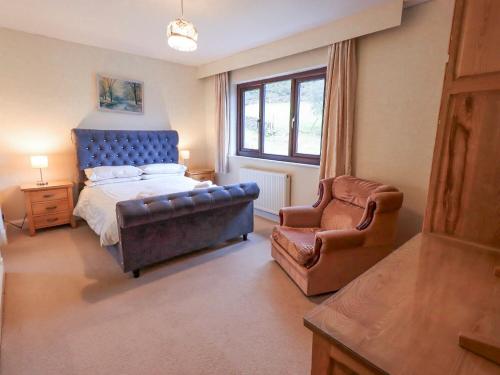 a bedroom with a bed and a couch and a chair at Ghyll Bank House in Staveley