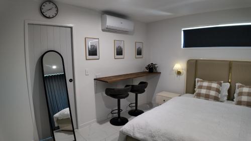 a bedroom with a bed and a mirror and a desk at Taupo Premium Retreat - Private Spa & Ensuite in Taupo