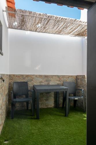 a table and two chairs and a table and some grass at Di&Ana - Alojamento Redondo in Redondo