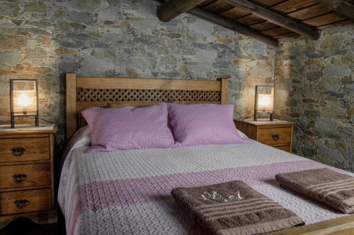 a bedroom with a bed with purple sheets and two lamps at Di&Ana - Alojamento Redondo in Redondo