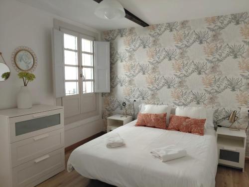 a bedroom with a white bed and a wall at Casa dos Cantares in Padrón