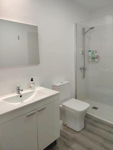 a white bathroom with a sink and a toilet at Casa dos Cantares in Padrón