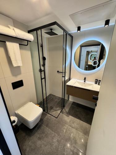a bathroom with a toilet and a sink and a mirror at נווה ים סוף - מתחם דירות נופש פרימיום באילת in Eilat