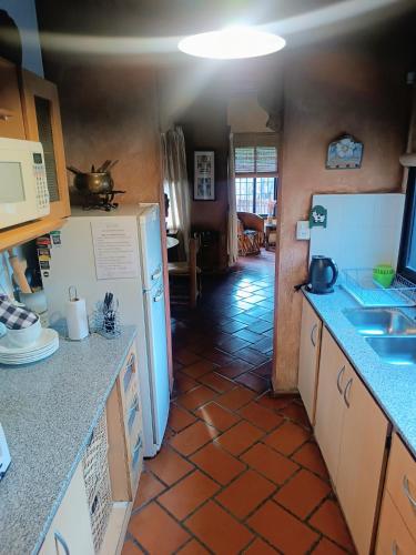 a kitchen with white appliances and a tile floor at Casa Darragueira de Chacras de Coria in Chacras de Coria