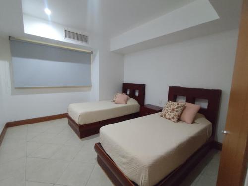 a room with two beds and a window in it at IXTAPA LUXURY - BVG 405 Norte in Ixtapa