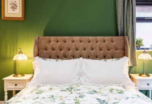 a green bedroom with a bed with white pillows at Beech Tree Park Cottages in Hatfield