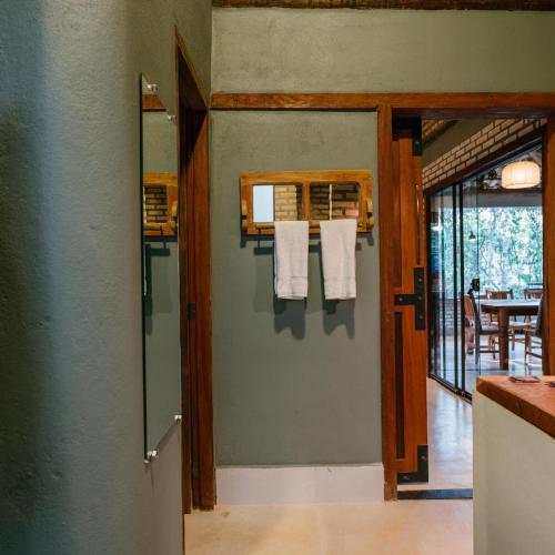 a bathroom with towels hanging on the wall at Chalé Tororão - São Jorge GO in Sao Jorge