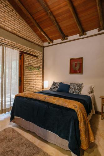 a bedroom with a large bed in a room at Chalé Tororão - São Jorge GO in Sao Jorge