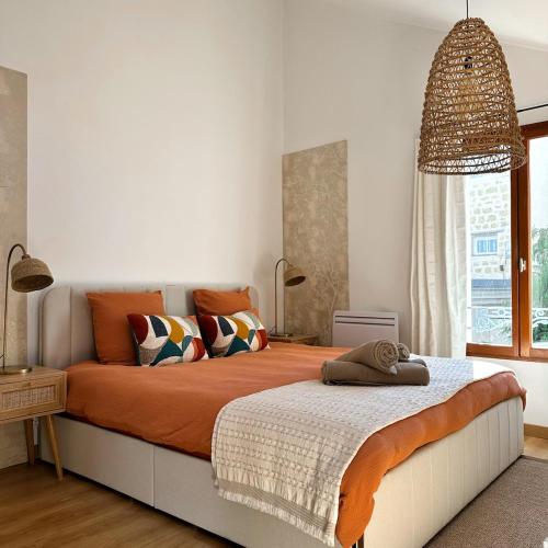 a bedroom with a large bed with an orange blanket at Echappée Bleue in Auvers-sur-Oise