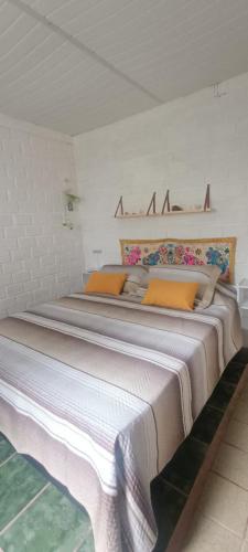 a bedroom with a large bed with orange pillows at La foca da Croa in Goiana