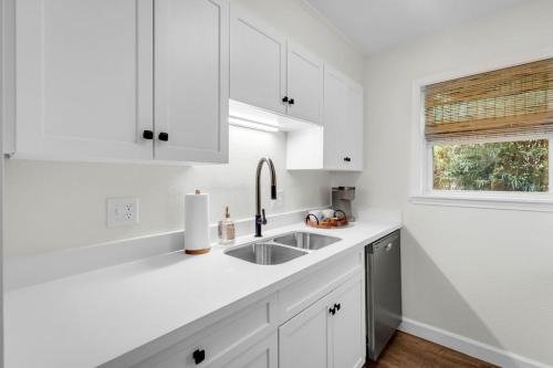 a white kitchen with a sink and a window at The Porter Chamber in Ocean Springs
