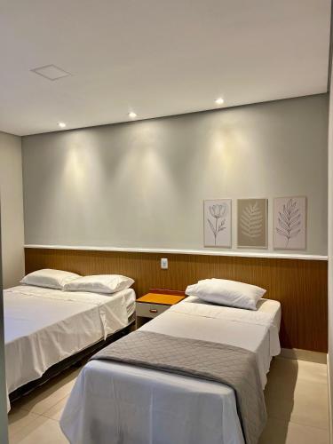 a room with two beds and a large wall at Pousada Bella in Vitória da Conquista