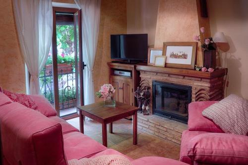 a living room with a fireplace and a tv at Patio de las Flores in Riópar