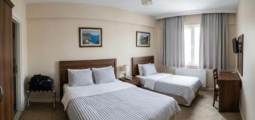 a hotel room with two beds and a window at Rasim otl in Göksun