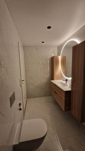 a bathroom with a sink and a toilet and a mirror at Villa Modum in Skreppen