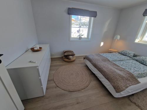 a bedroom with a bed and a dresser and a window at Villa Modum in Skreppen