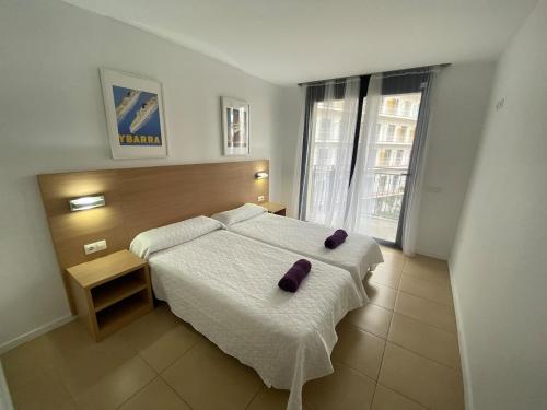 a bedroom with a bed with two purple pillows on it at Osaka Suite in Lloret de Mar