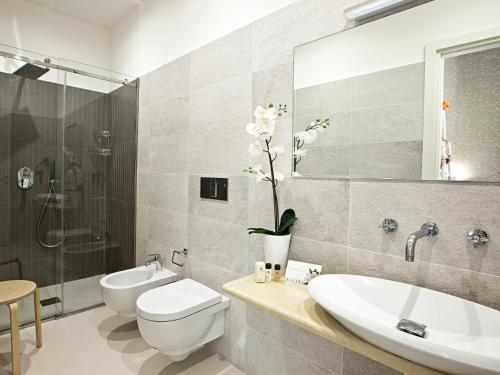 a bathroom with a sink and a toilet and a shower at Parthenope Suite in Naples
