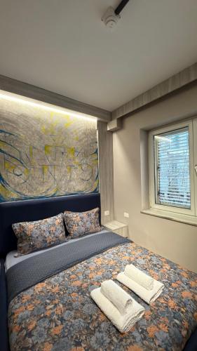a bedroom with a bed with two towels on it at Agora ApartHotel in Tirana
