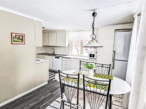 a kitchen with a table and chairs and a refrigerator at Villa Äppelgården by Interhome in Örebro