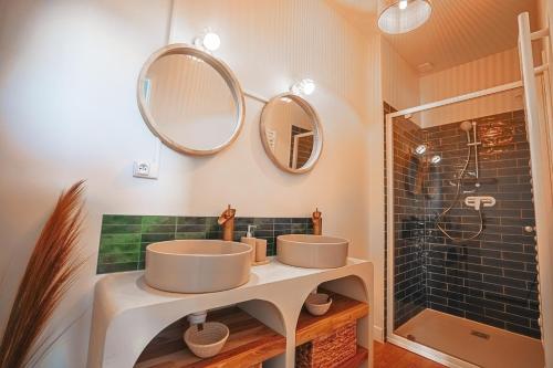 a bathroom with two sinks and a shower at L Escale Balinaise et Spa #7 in Agen