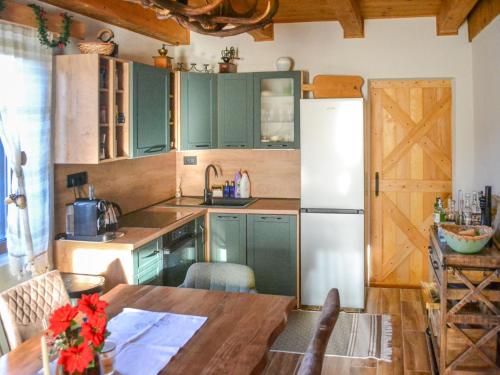 a kitchen with a wooden table and a refrigerator at Chalet Makov Hrib by Interhome in Tršće