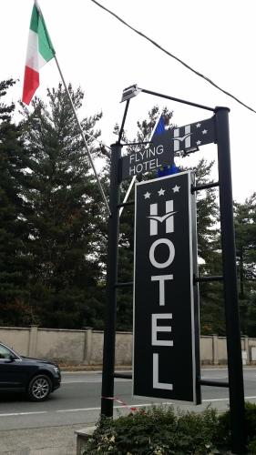 a sign for a king hotel with a flag on a street at Flying Hotel in San Maurizio Canavese