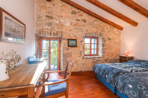 a bedroom with a bed and a desk and a table at Old Stonehouse Stari San in Pinezici